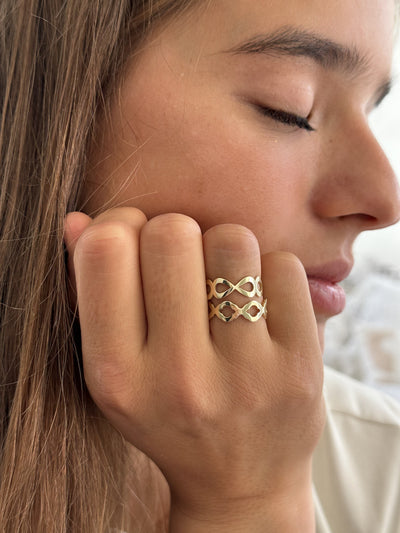 Model draagt 14 karaat gouden ring met ontwerp geinspireerd door druppels
