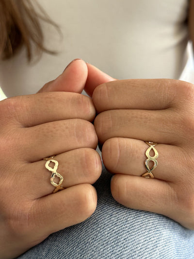 Model draagt 14 karaat gouden ring met ontwerp geinspireerd door druppels